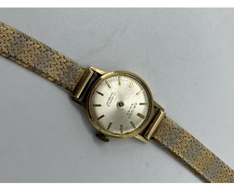 An Oriosa ladies 14ct gold manual wind wristwatch, the silvered dial having baton markers and having a bicoloured bracelet 18