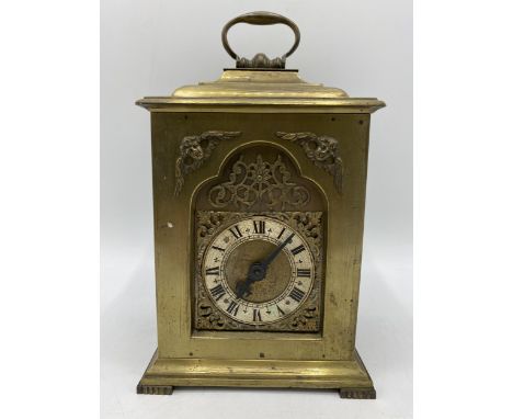 A late 19th century brass cased mantle clock having a silvered dial with Roman numerals with pierced gilt metal spandrels, fi
