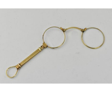 Early 20th century French gold coloured lorgnettes with a loop handle, button activated sprung lenses and engine turned decor