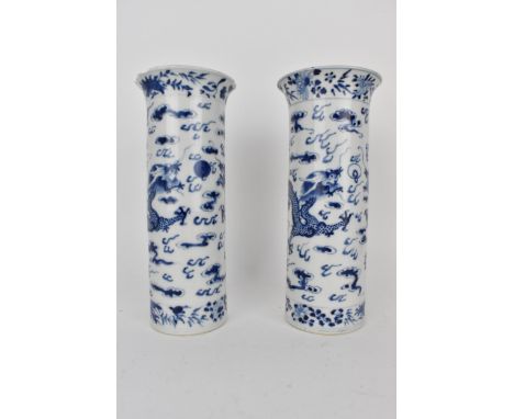 A pair of late 19th century Chinese blue and white porcelain vases of cylindrical form decorated with two dragons chasing a b