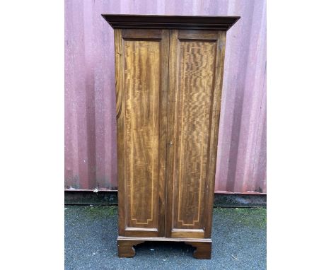 An Edwardian mahogany collectors cabinet having a stepped cornice, the two doors having satinwood banding and fitted with six