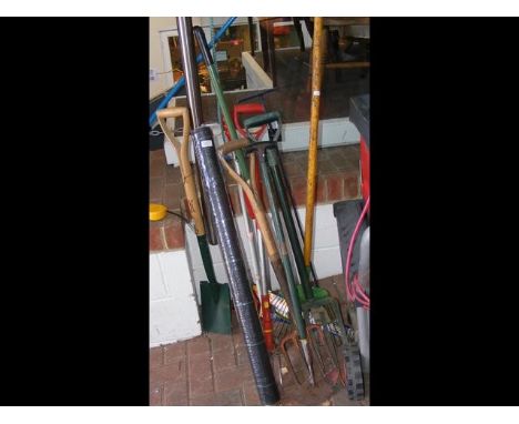A number of garden tools including spades and rakes etc