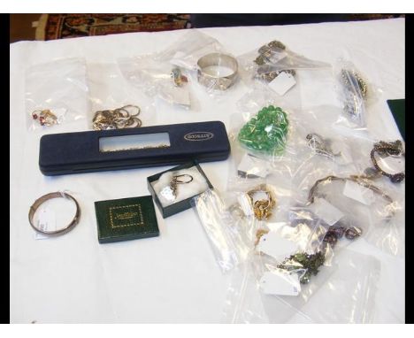 A silver bangle together with others and costume jewellery