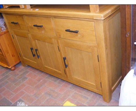 A 150cm light oak sideboard with three drawers and cupboards under 