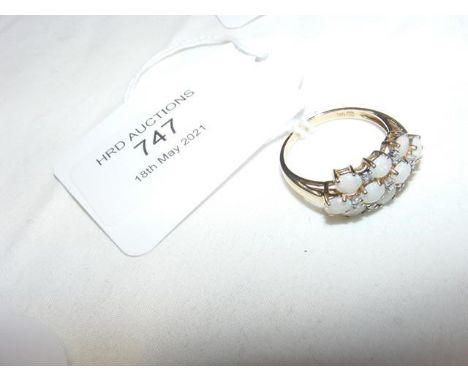 An opal and diamond ring in gold setting