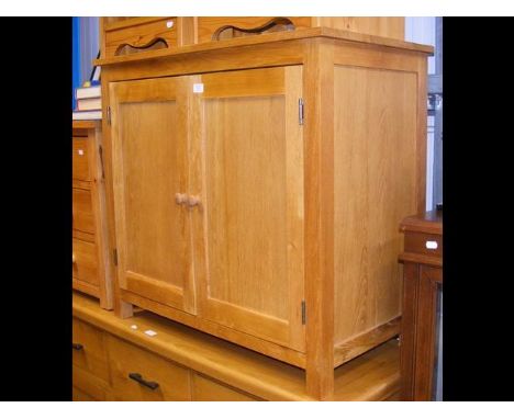 An 88cm light oak side cabinet, enclosed by a pair of panelled doors 