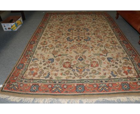 An Oriental carpet, the cream field of floral vines enclosed by terracotta borders, 364cm by 241cm 