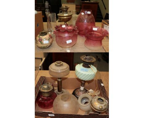 Three oil lamp bases and a collection of etched and other cranberry and clear glass shades etcSome of the shades with small c