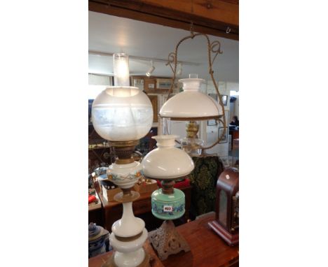 Two oil lamps with glass reservoirs (one painted), and a hanging oil lamp with clear glass reservoir