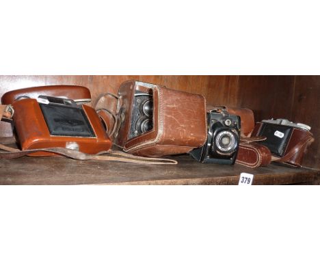 A Rolleiflex TLR camera in leather case, two Agfa Isolette cameras and a Robi camera