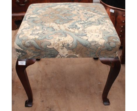 AN ANTIQUE, POSSIBLY ELM, OVERSTUFFED UPHOLSTERED STOOL standing on square tapering cabriole legs terminating in square secti