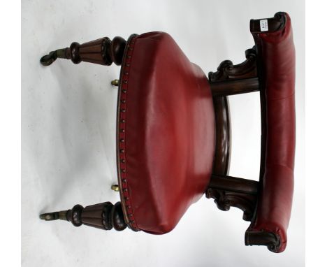 A WILLIAM IV MAHOGANY RED LEATHERETTE LIBRARY ARMCHAIR with carved scrolling supports, overstuffed upholstered ring back and 
