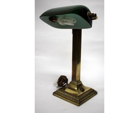 A BRASS DESK LAMP with green glass shade and standing on square spreading base, 45cm tall