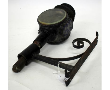 AN OLD BLACK PAINTED WROUGHT IRON CARRIAGE LAMP with double height louvers, circular lens and blue and rose etched glass wind