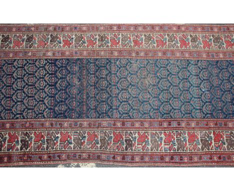 AN OLD MIDDLE EASTERN BLUE GROUND RUNNER the central repeating field within geometric and triple banded border, approximately