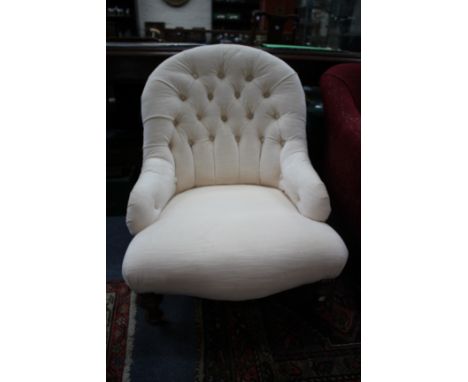 A VICTORIAN CREAM BUTTON UPHOLSTERED LOW OCCASIONAL CHAIR with turned tapering front legs terminating in white ceramic caster