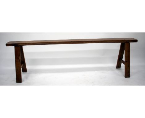 AN EARLY 20TH CENTURY POSSIBLY FRUITWOOD BENCH with single beam top and standing on square section legs united by stretchers,