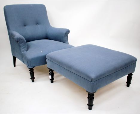 A LATE 19TH/EARLY 20TH CENTURY BLUE LINEN UPHOLSTERED TWO BUTTON BACK LIBRARY ARMCHAIR, standing on ebonised turned tapering 