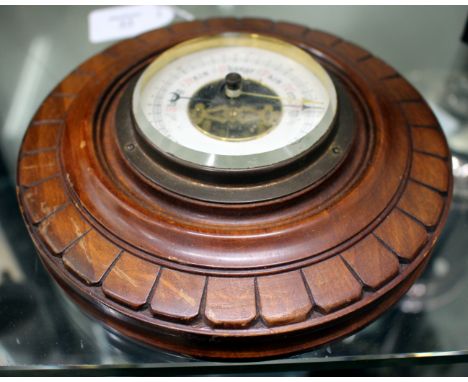 A HARDWOOD CASED CIRCULAR ANEROID BAROMETER with ring suspension to the top 17.5cm diameter 