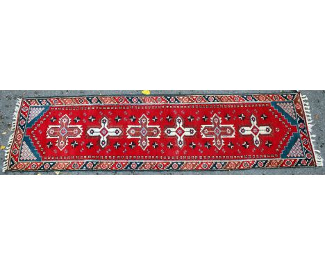 A LATE 20TH CENTURY MIDDLE EASTERN RED GROUND RUNNER with a banded border and Central motifs 76cm x 282cm together with a lat