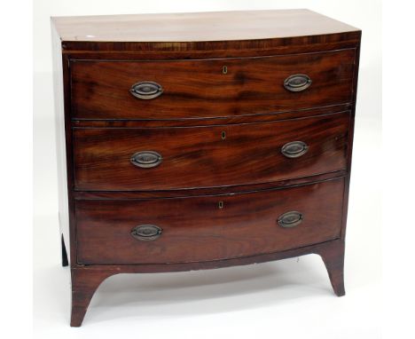 A 19TH CENTURY BOW FRONTED MAHOGANY CHEST of three graduated long drawers, each with brass ring handles and standing on outsw