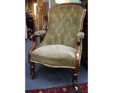 A VICTORIAN MAHOGANY BUTTON UPHOLSTERED OPEN ARMCHAIR with serpentine fronted seat and standing on ring turned tapering legs 