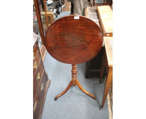 AN ANTIQUE PINE AND MAHOGANY CIRCULAR TILT TOP OCCASIONAL TABLE with ring turned decoration to the column support and on a tr