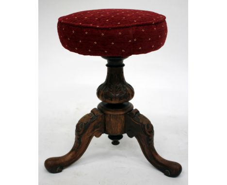 A VICTORIAN WALNUT CIRCULAR MUSIC STOOL with tripod base, 50cm tall 