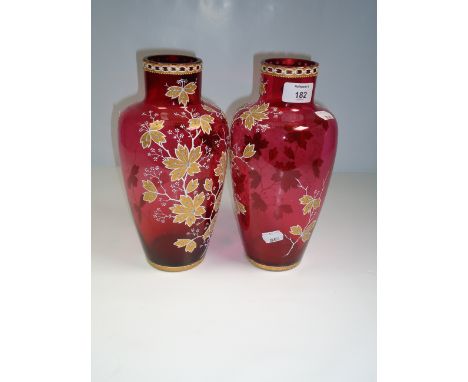 A pair of Edwardian cranberry florally enamel decorated glass vases