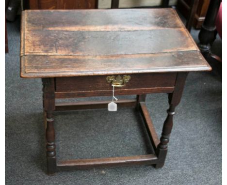 An 18th century oak side table, the planked top with moulded edge over frieze drawer with later brass handle on baluster and 