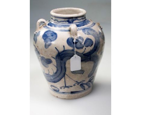 A Chinese swatow blue and white pottery vase, with lug handles, painted with stick leg dragons, clouds and waves, 26cm