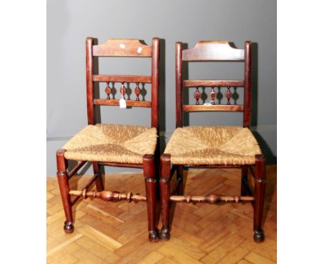A pair of early 19th century regional/Lancashire side chairs, with profile bobbin back over rush seats and bulbous turned cab