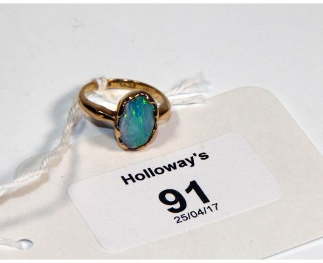 An 18ct gold dress ring, opal set with an oval shaped opal (doublet)