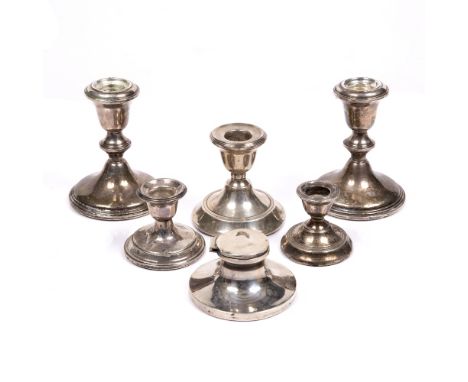 A collection of five various silver candlesticks and a silver capstan inkwell