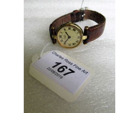 Must de Cartier, a lady's silver gilt wristwatch, circular cream enamel dial, Roman numerals, silver-gilt lugs and leather st