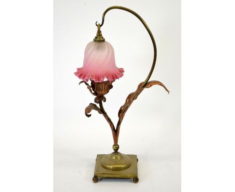 An Arts and Crafts brass and copper table lamp, in the style of W A S Benson, after model 965, with hanging cranberry glass c