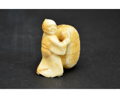 λ A 19th century Japanese carved ivory netsuke, Meiji, modelled as small man with bag of wheat, 4cm high