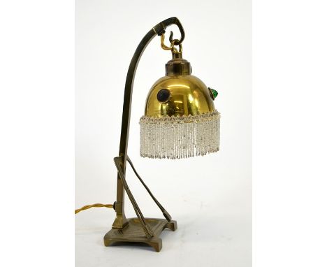 A Secessionist brass table lamp, the square section support with buttress and embossed tray base, suspending a domed shade wi