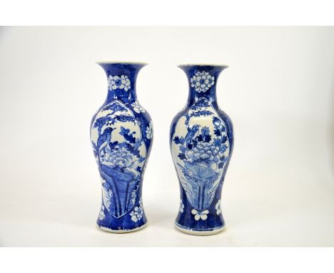 A pair of Chinese blue and white vases, Kangxi mark, shouldered form, painted with panels of birds in branches, 30cm high (2)