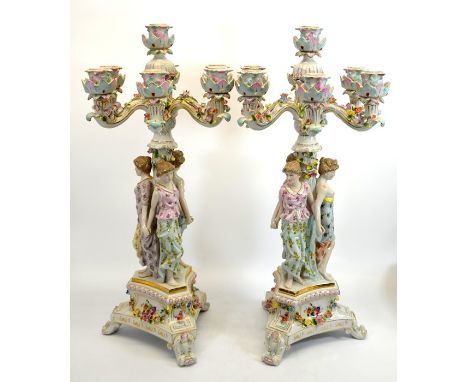A pair of Continental style figural Three Graces candelabra, florally encrusted, each with six branches, on tricorn bases and
