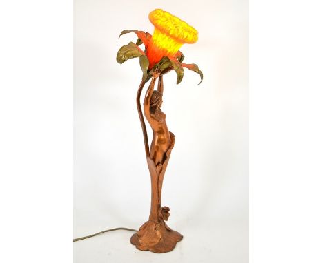 An Art Nouveau figural table lamp, coppered finish, modelled as a woman holding a flower, arms raised, with orange mottled ar