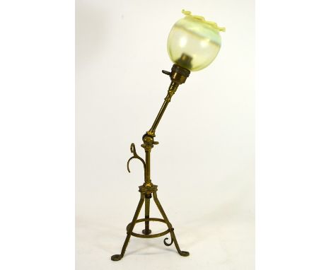 An Arts and Crafts Pullman type brass table lamp, adjustable, tripod form with hanging hooks and screw fixing feet, with a st