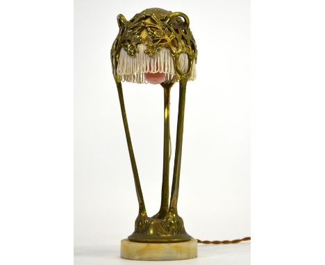 Maurice Maignan, an Art Nouveau cast brass table lamp, circa 1905, the fabric shade encased within an open cast dome of prunu