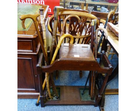 An early 20th century oak stick-stand and a quantity of walking sticks and canes