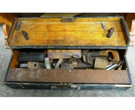 A toolbox with contents to include wooden planes and chisels.