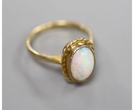 A 9ct and oval white opal set dress ring, size K, gross 2.6 grams.