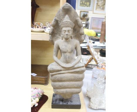 A large stone figure in the style of a Cambodian Buddha, on stand, height 68cm