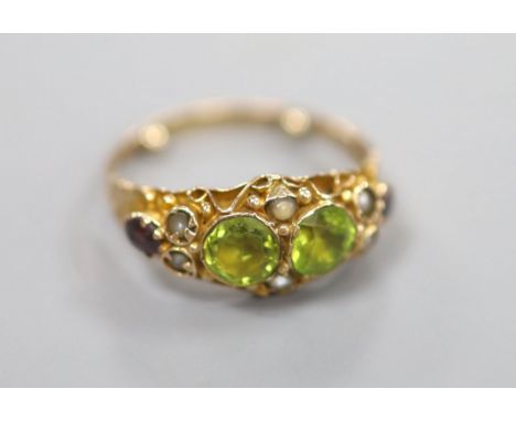 A George V 9ct gold, peridot, seed pearl and garnet set dress ring, in the Suffragette colours, size K, gross 2 grams.CONDITI