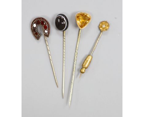 Four assorted early 20th century gem set stick pins including 15ct and diamond chip.