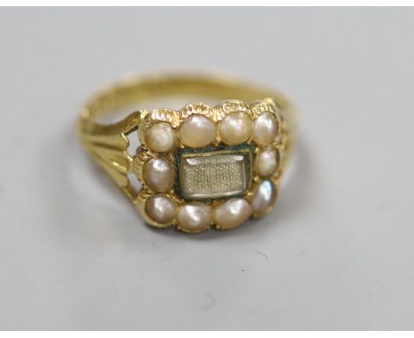 An early Victorian 18ct gold, split pearl and enamel(a.f.) mourning ring, with central glazed panel above plaited hair, ring 